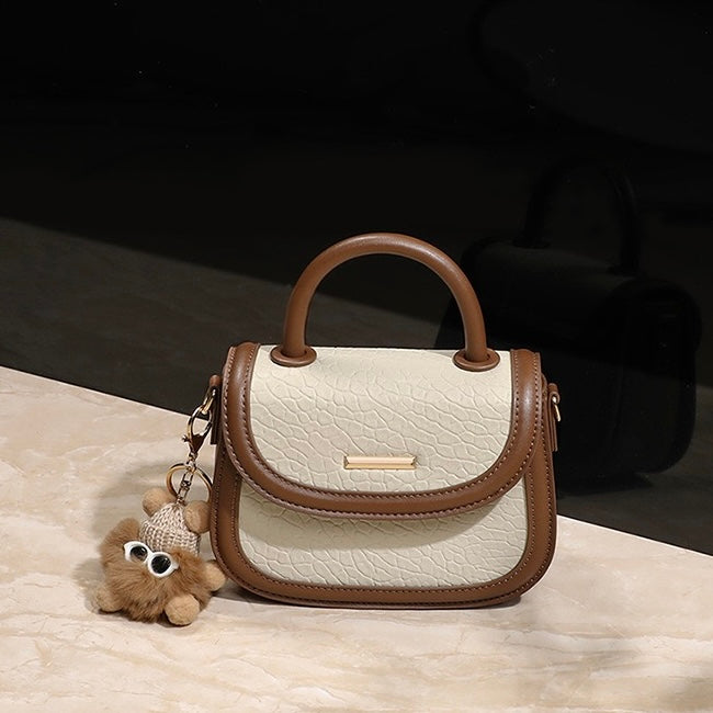 Damen-Handtasche aus echtem Leder mit Farbblock und pelzigem Anhänger