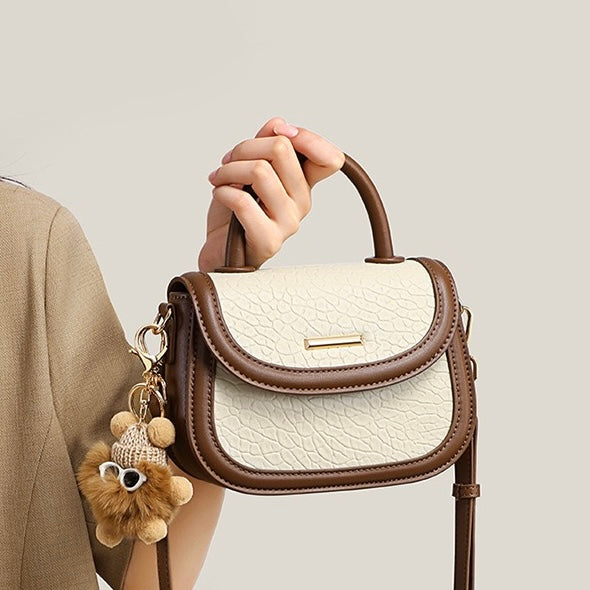 Damen-Handtasche aus echtem Leder mit Farbblock und pelzigem Anhänger