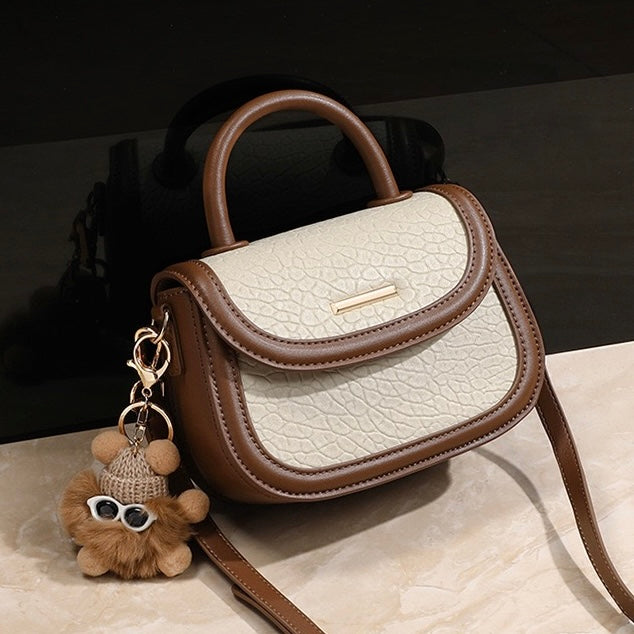 Damen-Handtasche aus echtem Leder mit Farbblock und pelzigem Anhänger