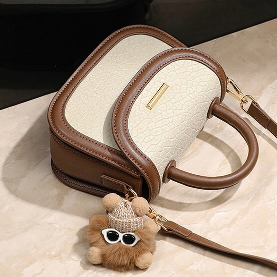 Damen-Handtasche aus echtem Leder mit Farbblock und pelzigem Anhänger