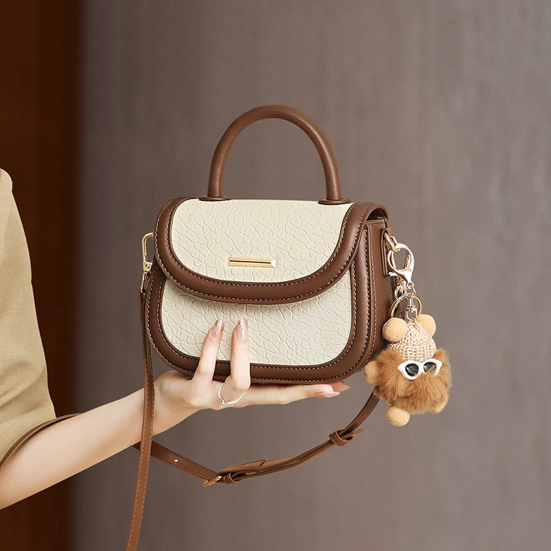 Damen-Handtasche aus echtem Leder mit Farbblock und pelzigem Anhänger