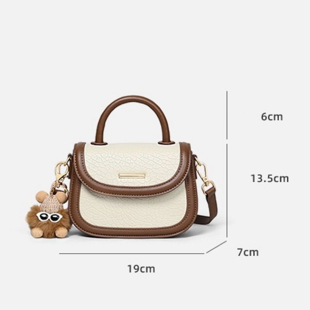 Damen-Handtasche aus echtem Leder mit Farbblock und pelzigem Anhänger