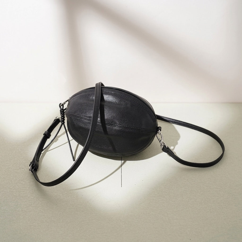 Moderne, geschmeidige ovale Rugby-Clutch aus echtem Lammleder
