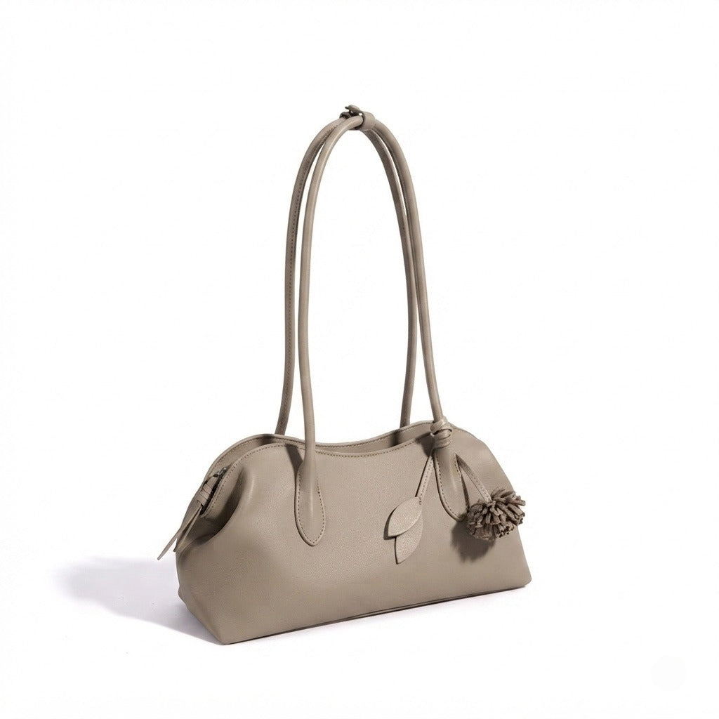 Borsa pochette minimalista curva in vera pelle morbida con ciondolo giocoso
