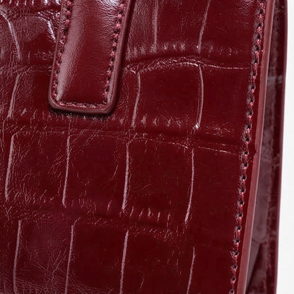 Borsa pochette raffinata in ecopelle vegana lucida con stampa effetto coccodrillo, con charm chic