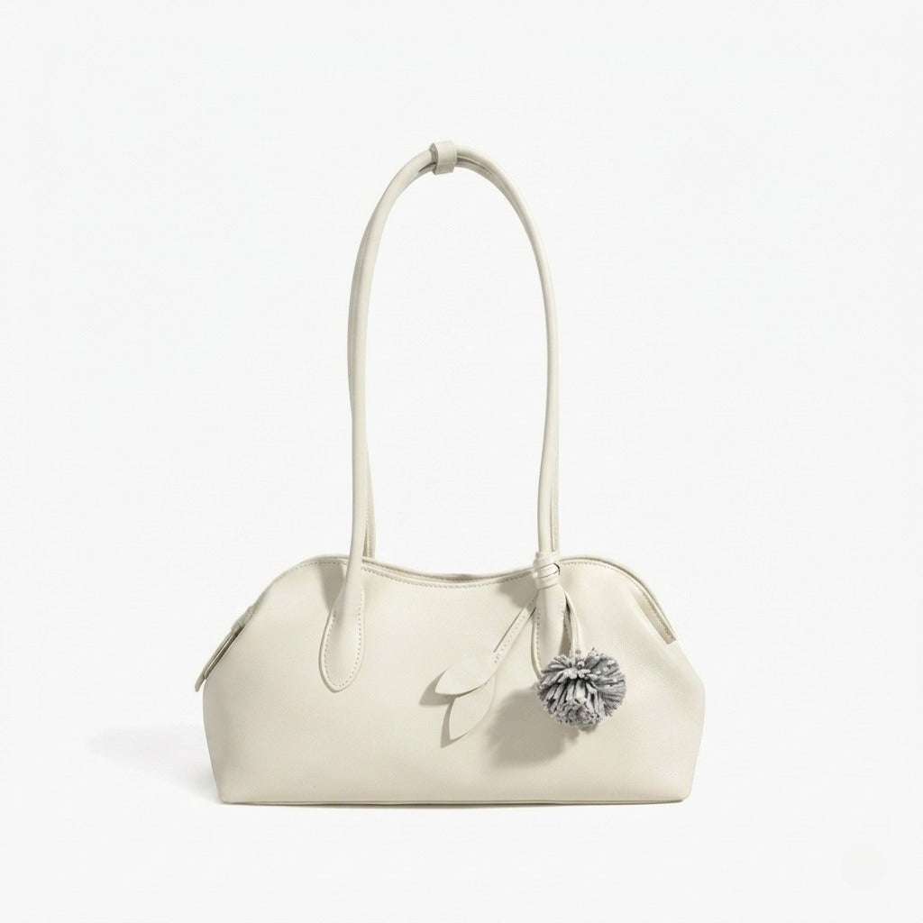 Borsa pochette minimalista curva in vera pelle morbida con ciondolo giocoso