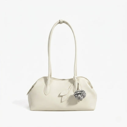 Borsa pochette minimalista curva in vera pelle morbida con ciondolo giocoso