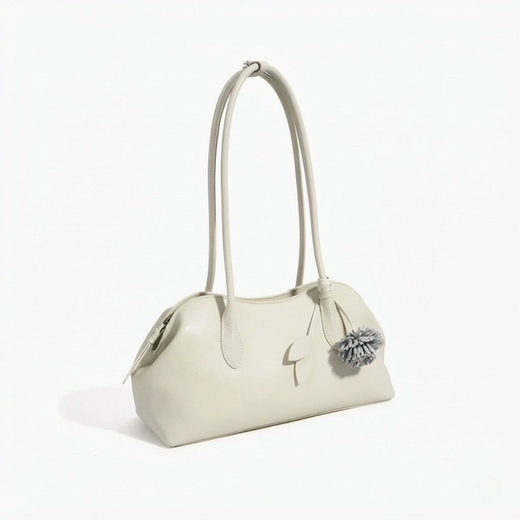 Borsa pochette minimalista curva in vera pelle morbida con ciondolo giocoso
