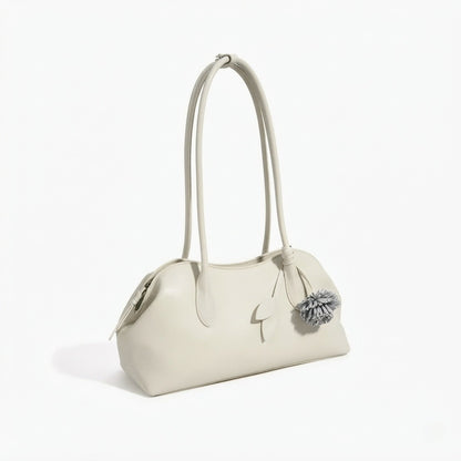 Borsa pochette minimalista curva in vera pelle morbida con ciondolo giocoso