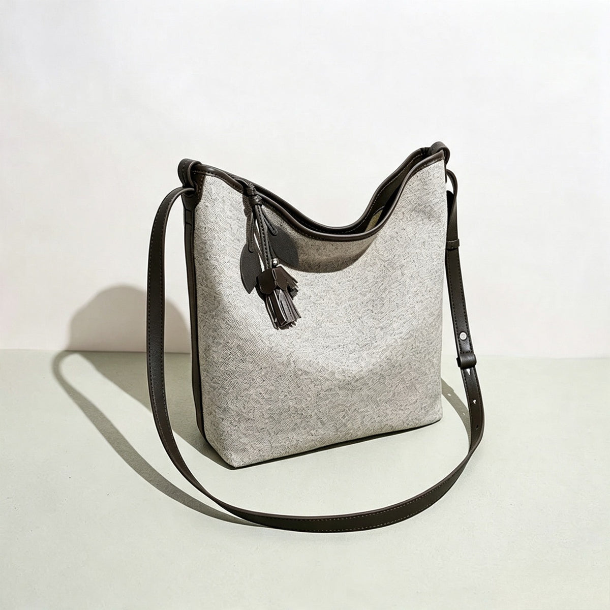 Borsa pochette a secchiello morbida in tela con ciondolo a nappa