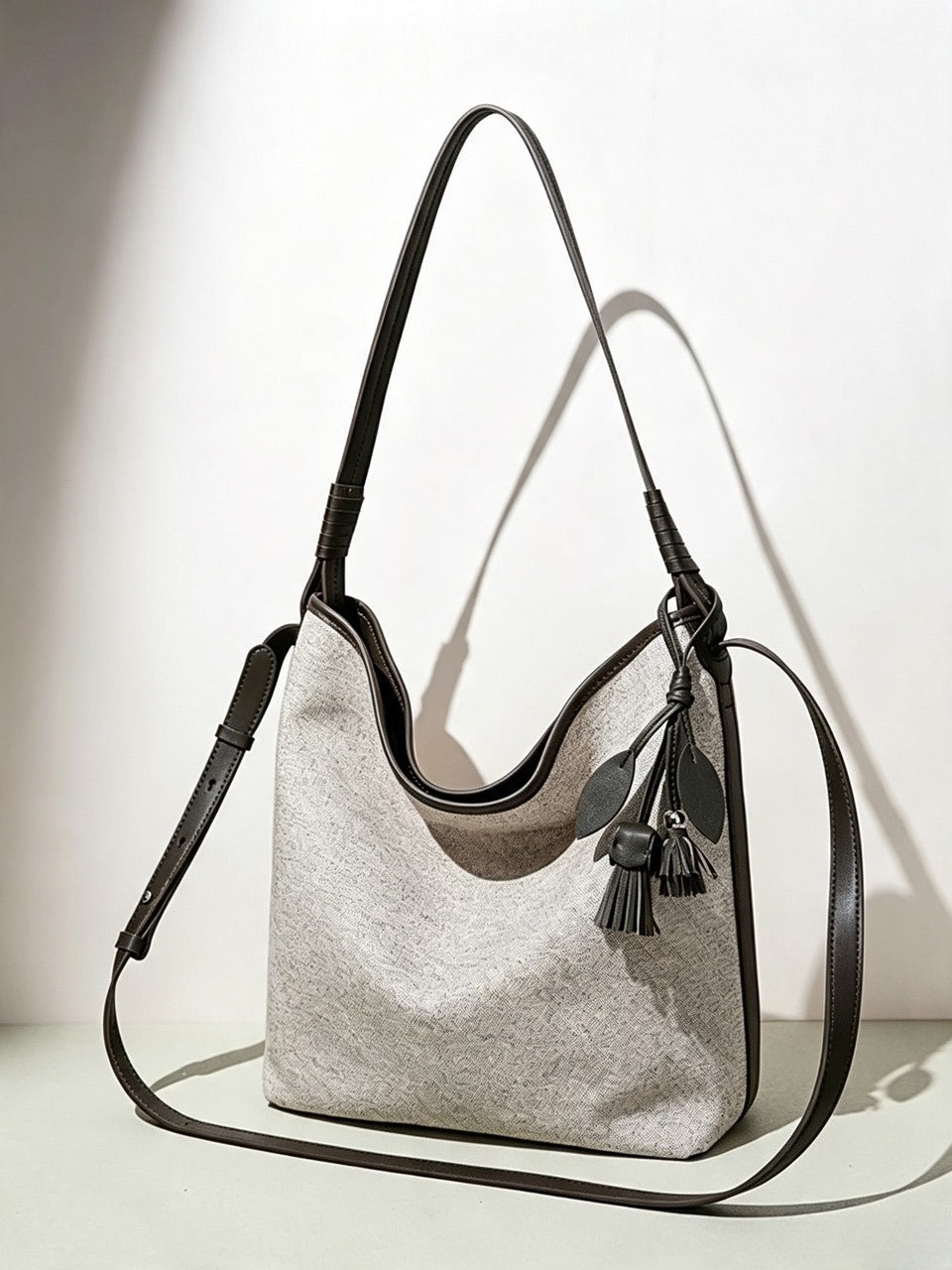 Borsa pochette a secchiello morbida in tela con ciondolo a nappa