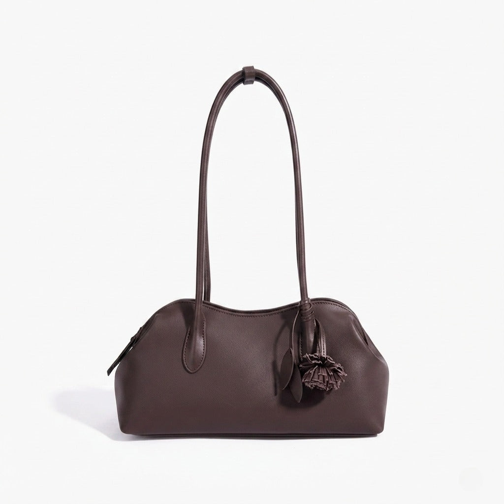 Borsa pochette minimalista curva in vera pelle morbida con ciondolo giocoso