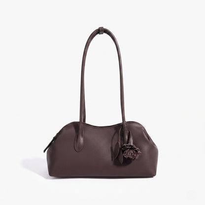 Borsa pochette minimalista curva in vera pelle morbida con ciondolo giocoso