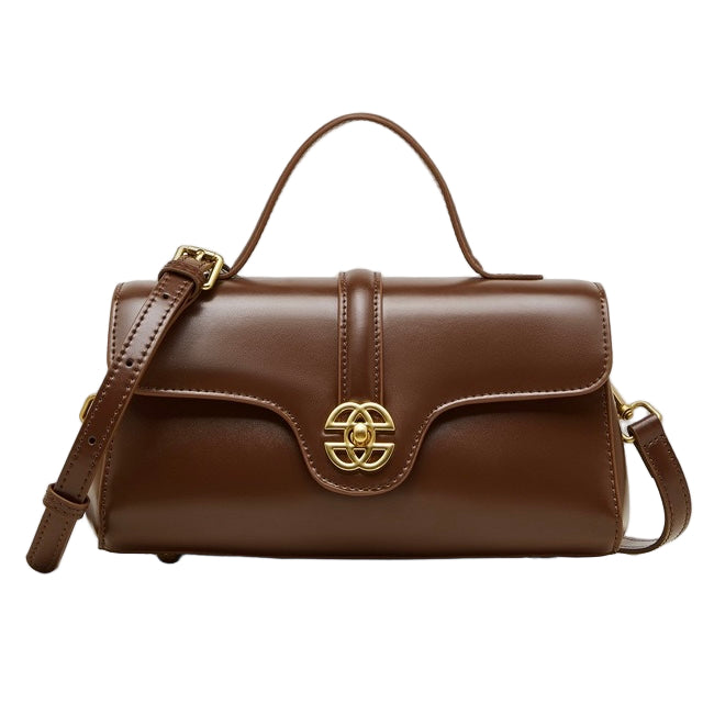 Brown leather handbag with gold emblem on a white background