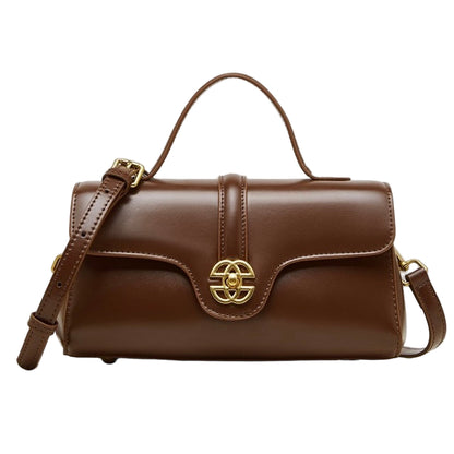 Brown leather handbag with gold emblem on a white background