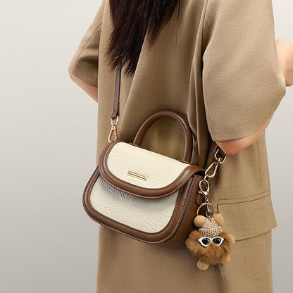 Damen-Handtasche aus echtem Leder mit Farbblock und pelzigem Anhänger