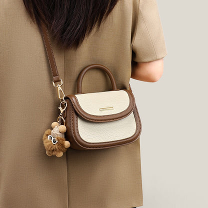 Damen-Handtasche aus echtem Leder mit Farbblock und pelzigem Anhänger