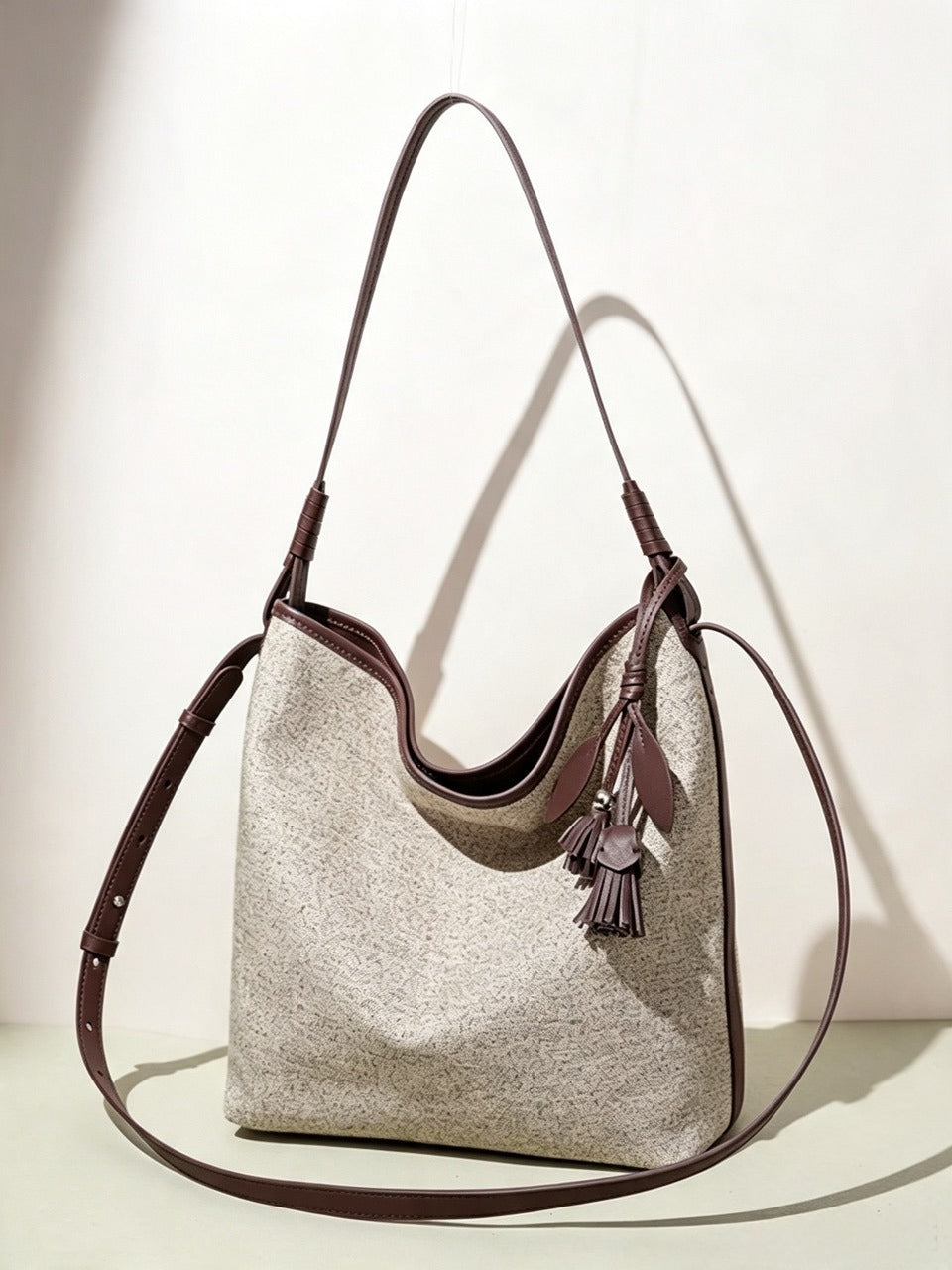 Borsa pochette a secchiello morbida in tela con ciondolo a nappa