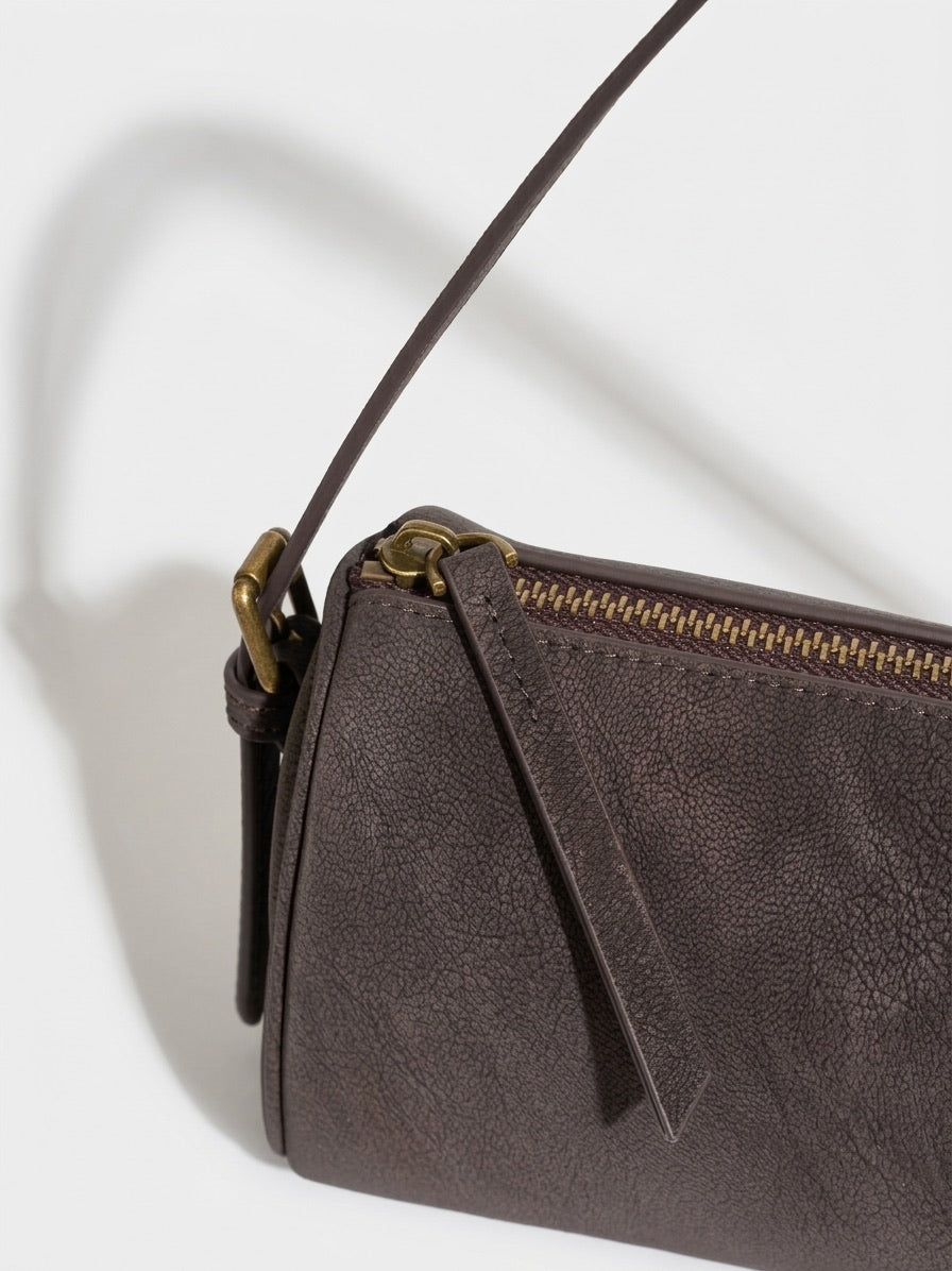 Geantă clutch rustică, mată, cilindrică, din piele autentică cu aspect uzat, purtată crossbody