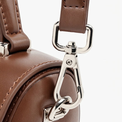 Bolso de mano tipo clutch cilíndrico de cuero genuino con estilo chic  