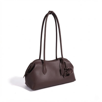 Borsa pochette minimalista curva in vera pelle morbida con ciondolo giocoso